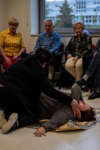 Seniorka podczas ćwiczenia pierwszej pomocy - układanie w pozycji bocznej ustalonej