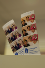 Dwa wydruki zdjęć z fotobudki z logotypem Trzeciego Wieku, przedstawiające uśmiechnięte słuchaczki pozujące w zabawnych rekwizytach, w tym w różowej czapce w kształcie flaminga.